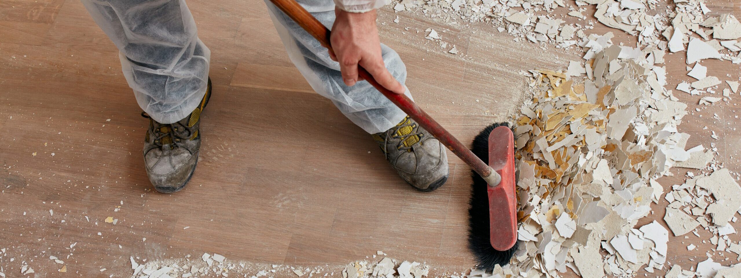 Builder sweeping the floor after renovation
